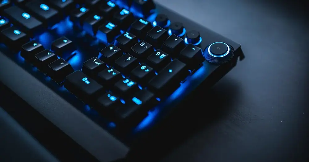 Teclado mecânico com luz azul sobre uma mesa escura, cena de digitação para sites para inverter texto online